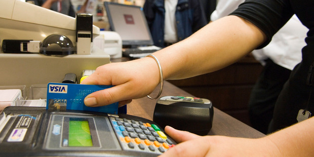 A sales clerk swipes a customer's Visa card at a shop in Wellington.