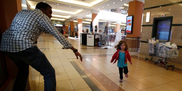Abdul Haji reaches out for Portia Walton as she runs toward him in the Nairobi shopping centre. Photo / Reuters