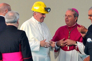 Pope Francis, with Cagliari Archbishop Arrigo Miglio, wears the helmet he was given by a coalminer during his visit to the capital of Sardinia. Photo / AP