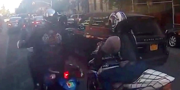 Riders pulled the SUV driver from the vehicle after it became stuck in traffic. Photo / AP