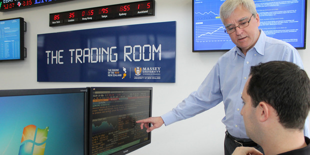 Professor Russell Gregory-Allen discusses information with postgraduate student Sam Weir in Massey University's Albany campus trading room.
