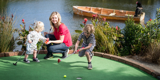 Rachel Grunwell plays mini golf with her sons Finn (L) and Lachlan at Treasure Island. Photo / Michael Craig