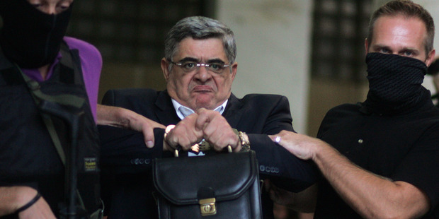 Leader of the extreme far-right Golden Dawn party Nikos Michaloliakos, centre, is escorted by anti-terror police as he exits Greek Police headquarters, in Athens. Photo / AP