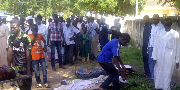 Rescue workers and family members gather to identify the victims of the Boko Haram attack. Photo / AP