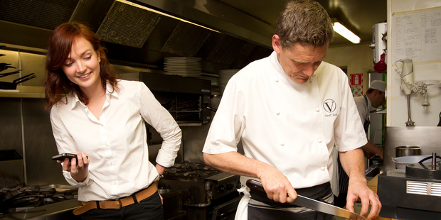 Amelia Wade watches the timer as Geoff Scott of Vinnie's in Herne Bay attempts one of Jamie Oliver's 15 minute meals. Photo / Sarah Ivey