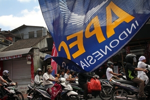 Motorcyclists make their way through a street decorated with banners for the Apec meetings in Bali. Photo / AP
