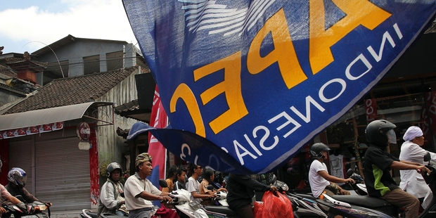 Motorcyclists make their way through a street decorated with banners for the Apec meetings in Bali. Photo / AP