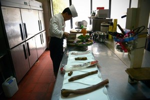A cook preparing a dish of animal penis in the kitchen.Photo / AFP