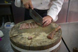 A cook preparing a dish of animal penis in the kitchen.Photo / AFP
