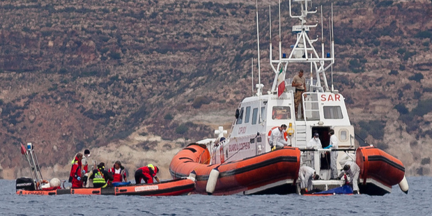Italian Coast Guard personnel recover a body bag on their patrol boat in Lampedusa island. Photo / AP
