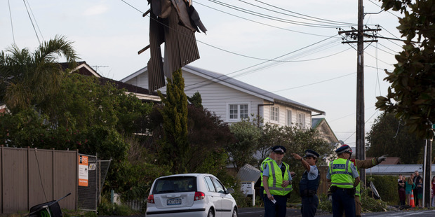 The remains of roofing iron hanging from powerlines on Vauxhall Road, Devonport, after the storm. Photo / Brett Phibbs