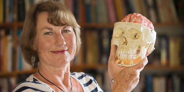 Neuropsychologist Jenni Ogden, in her library on Great Barrier Island, with a model of a brain. Photo / Greg Bowker