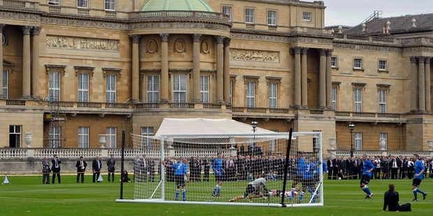 Polytechnic FC (in blue), take on Civil Service FC in the Buckingham Palace garden. Photo / AP