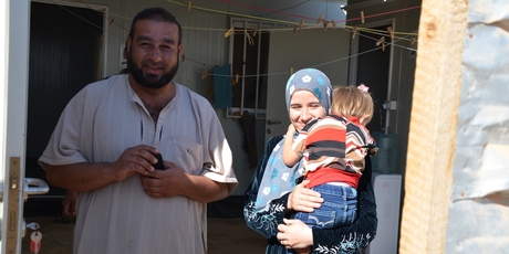 Zuheir and Omayma with their daughter Salaam in the doorway of their container home. Photo / Kate Shuttleworth