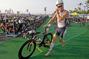Competitor Frederik Van Lierde, of Belgium, runs with his bicycle on the Kailua Pier to begin a 112-mile ride in the Ironman World Championship Triathlon on Saturday. Photo / AP.