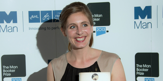 New Zealand author Eleanor Catton poses after being announced the winner of the Man Booker Prize for Fiction, holding her prize and her book for the photographers. Photo / AP
