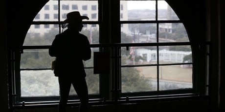 A visitor looks out on to Dealey Plaza from what is now the Sixth Floor Museum. About 50 years ago, Lee Harvey Oswald also looked out ... through the sights of a US$12 rifle. Photo / AP