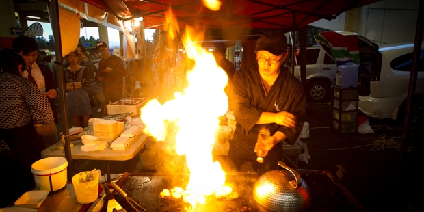 Chris Pei cooks up a storm in his stall at the Sunday night market at Glenfield. Photo / Richard Robinson