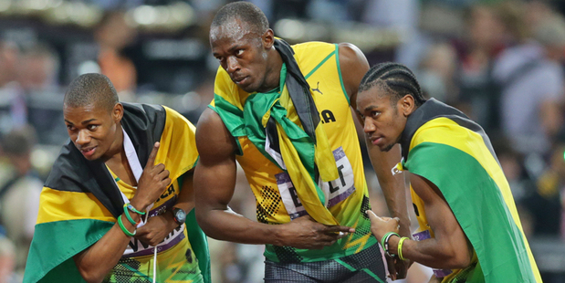 Usain Bolt of Jamaica after winning the gold in the final of the 200m, with teammates Warren Weir and Yohan Blake. Photo / Brett Phibbs