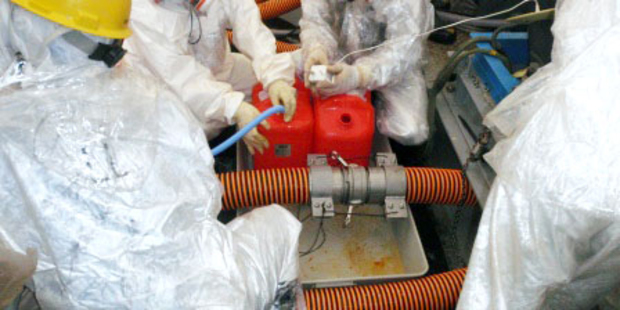 NRA officers check a pipe by which workers at Japan's crippled nuclear power plant was accidentally. Photo / AP