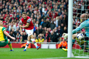 Arsenal's Aaron Ramsey, centre, shoots to score past Norwich City's goalkeeper John Ruddy, during their English Premier League soccer match, at the Emirates Stadium. Photo / AP