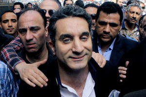 A bodyguard secures popular Egyptian television satirist Bassem Youssef, who has come to be known as Egypt's Jon Stewart. Photo / AP