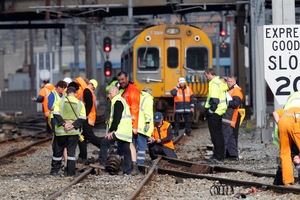 OFF TRACK: KiwiRail staff inspecting debris and damage after the passenger unit of a commuter train derailed. PHOTO/MARK MITCHELL