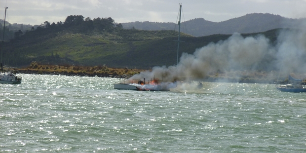 A plume of smoke floats across Whangarei Harbour as a trimaran burns. Photo / Bryn Heatley