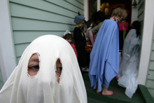 Ghost boy helps other scary looking kids invade another house for treats as they take part in Halloween.