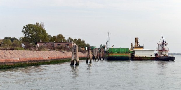 Barges in front of San Biagio Island, a man-made island which has been used as a garbage dump for years but could be turned into a fun park. Photo / AFP
