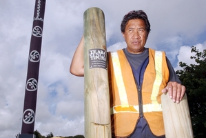 CARVED UP: Craftsman Hugh Tareha before the great pou he has both carved and been forced to repair after a chainsaw attack. PHOTO/PAUL TAYLOR HBT133530-01