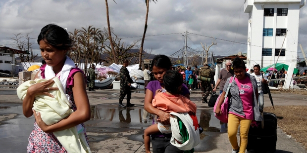 Typhoon survivors in Tacloban head for a United States military transport plane. Photo/ AP