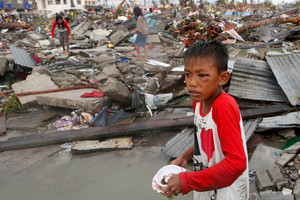 Residents gather coins and other salvageable materials from the ruins of houses after Super Typhoon Haiyan battered Tacloban city.