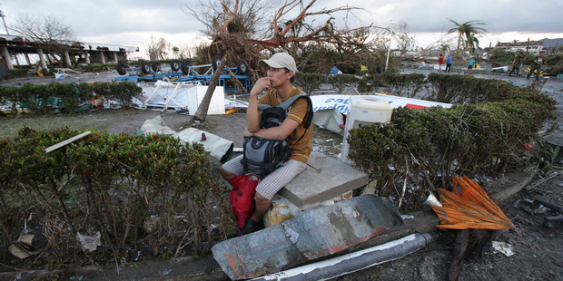 A man sits in the debris after powerful typhoon Haiyan slammed into Tacloban.Photo / AP