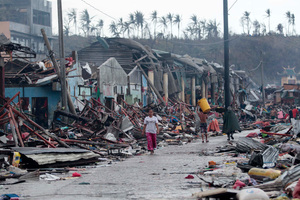 Residents walk past damaged structures caused by typhoon Haiyan. Photo / AP