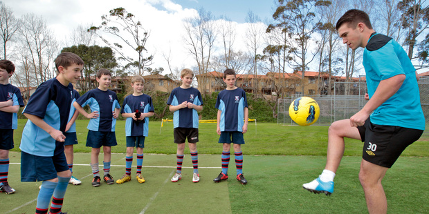 All Whites and Blackburn Rovers player Tim Payne (right) works with Sacred Heart's Alistair Tremlett (left) and his fellow students. Photo / APN