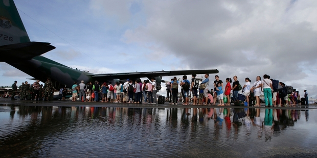Flights arrive at Tacloban crammed with aid and then leave with people lucky enough to get a place on the plane. Photo / AP