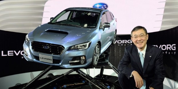 Fuji Heavy Industries President and CEO Yasuyuki Yoshinaga poses beside the company's new domestic sport touring wagon, "Subaru Levorg" during a press briefing at the Tokyo Motor Show 2013 Photo / AFP