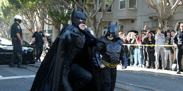 Miles Scott, dressed as Batkid, right, walks with Batman before saving a damsel in distress in San Francisco. Photo / AP