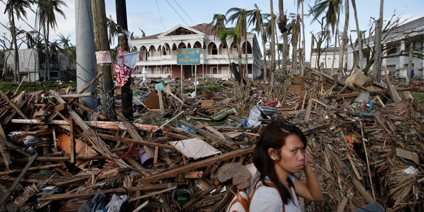 A typhoon survivor walks past the debris-littered Santo Nino Shrine and Heritage Museum which used to house former Philippine First Lady Imelda Marcos' collection of art pieces. Photo / AP