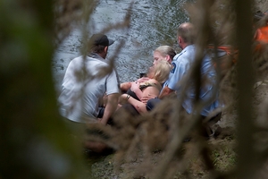 Police officers with the woman after she was taken to shore. Photo / Christine Cornege