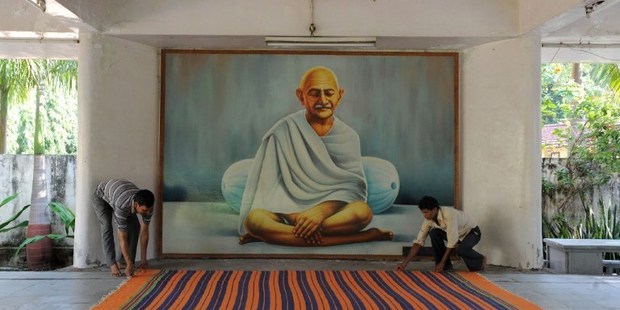 Caretaker, Bhim Bahdur (left) spreads a carpet in the prayer hall at Kochrab Ashram, site of the 'Live Gandhi for a While' programme in Ahmedabad. Photo / AFP