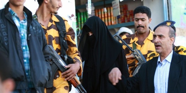 Yemeni security soldiers escort Saudi woman Huda al-Niran (C) and her lawyer Abdulraqib al-Qadi (R) outside the courthouse during her trial in the capital Sanaa. Photo / AFP