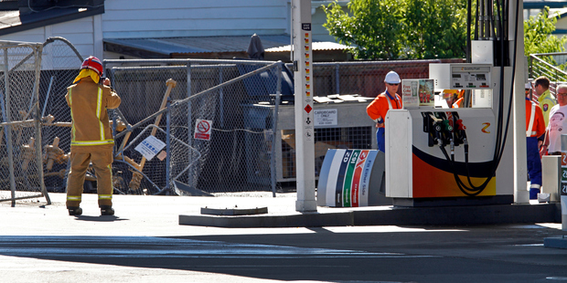 Gas workers and a Firefighter inspect the damage to mains supply pipes at the Z petrol station in Kamo, Whangarei after a City Link Bus collided with them. Photo / Kenny Rodger