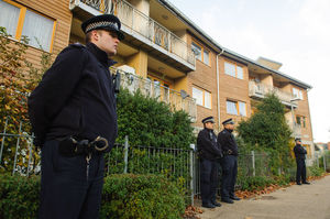 Police officers stand outside flats in the area where three women were rescued in south London. Photo / AP
