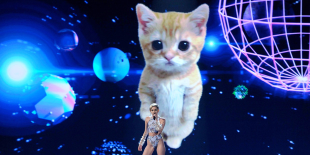 Miley Cyrus performs on stage at the American Music Awards in front of a giant space kitty. Photo / AP