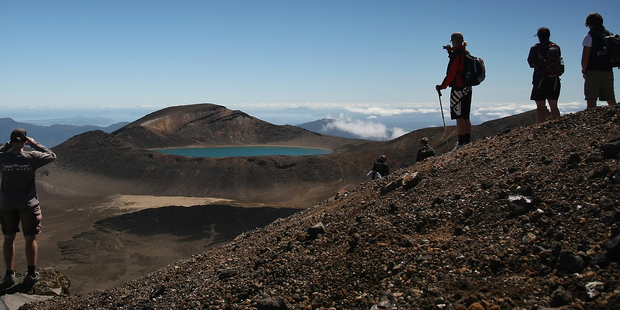 Tourists look towards Blue Lake, the half way point on the Tongariro Crossing in Tongariro National Park. Photo / Greg Bowker