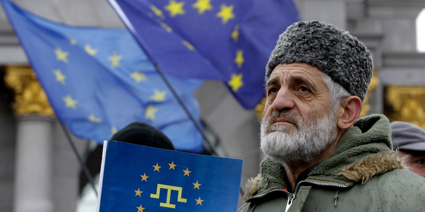 A demonstrator holds European Union flag during a protest in support of Ukraine's integration with the European Union in the center of of Kiev, Ukraine. Photo / AP