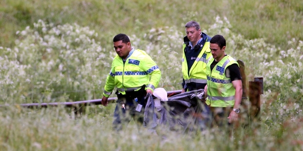 Police carry some of the couple's possessions after they were left stranded by the Ngaruroro River last night. Photo / Paul Taylor