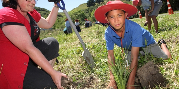 Clare Ridler from Horizons Regional Council and student Te Maramatanga Ponga, 9, plant native species at the Awarua Stream. PHOTO/BEVAN CONLEY